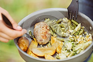 Man eating meat with rice and vegetables in the forest in sunny