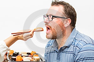 Man eating nagiri salmon with chopsticks