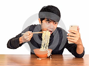 Man eating noodle and using smartphone isolate