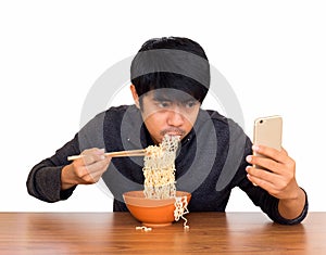 Man eating noodle and using smartphone isolate