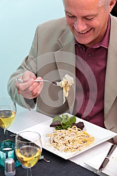 Man eating pasta in a restaurant