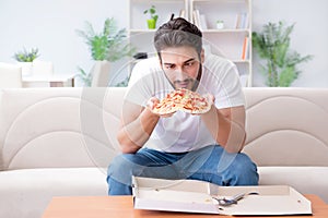 The man eating pizza having a takeaway at home relaxing resting