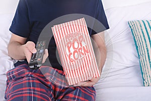 Man eating popcorn and watching movies.