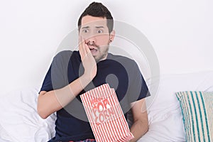 Man eating popcorn and watching movies.