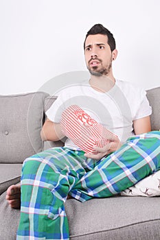 Man eating popcorn and watching movies.