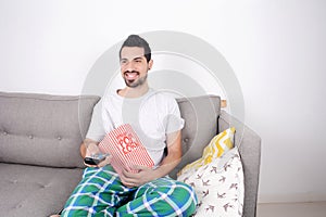 Man eating popcorn and watching movies.