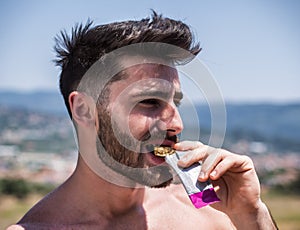 Man eating protein bar outdoor