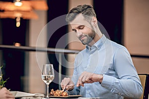 Man eating seafood at the restaurant and looking involved