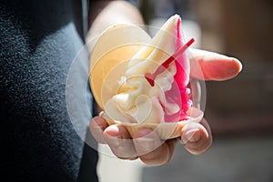 Man eating strawberry vanilla soft ice in typical eastern German DDR GDR waffle shell