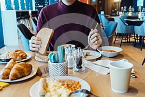 Man eating vegetarian English breakfast meal in the hotel restaurant. Continental breakfast concept. Selective focus, copy space