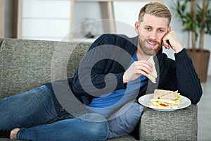 man eating while watching tv in living room