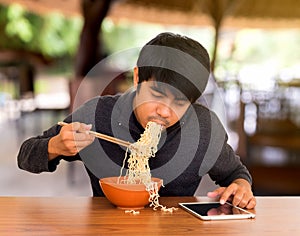 Man eating whilst looking and using tablet