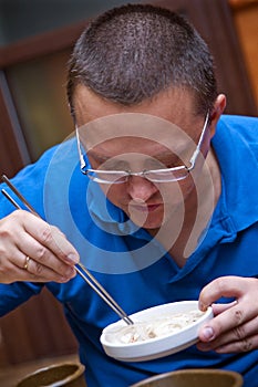 Man eats with chopsticks photo