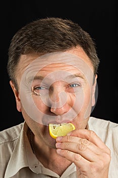 A man eats a lemon