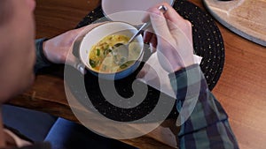 Man eats soup in kitchen. Vegetarian healthy meal for dinner.