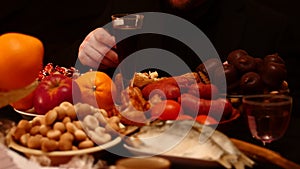 Man eats at the table, different food on black background
