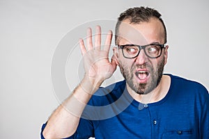 Man eavesdropping with hand close to ear