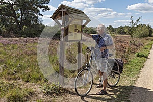 Man on an ebike is looking for information sign