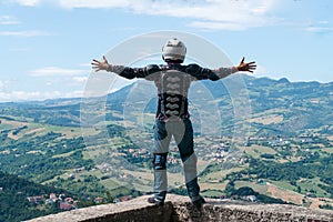 Man on the edge of the top of the world standing with raised hands. Destination scene. incredible view from the mountain.