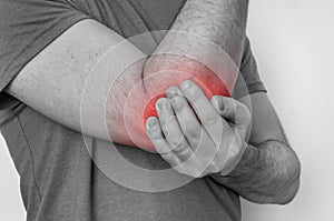 Man with elbow pain is holding his aching arm