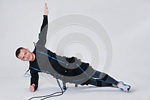 Man in an electric muscular suit for stimulation does the exercises