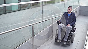 Man on electric wheelchair driving on a street. Accessibility concept photo