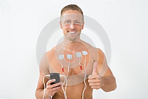 Man with electrodes showing thumbs up