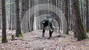 A man with an electronic metal detector in the forest