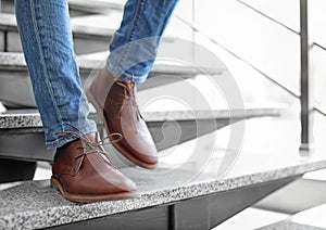 Man in in elegant shoes walking down stairs