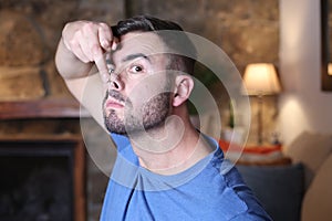 Man elevating nose tip with finger