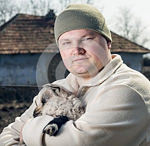 Man embracing a goatling.