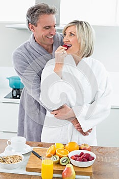 Man embracing a woman from behind in kitchen