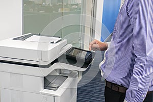 Man employee work with multifunction printer to scan and copy business documents in office