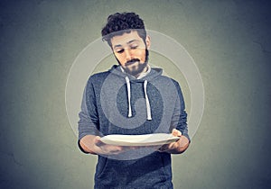 Man with empty plate looking sad