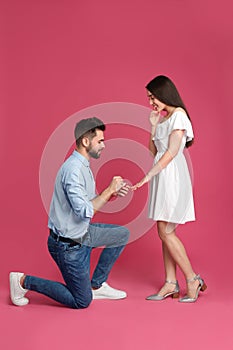 Man with engagement ring making marriage proposal to girlfriend on background