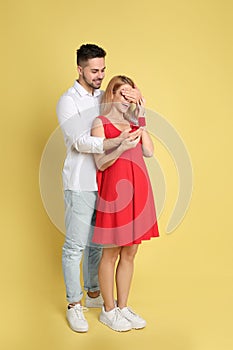 Man with engagement ring making marriage proposal to girlfriend on background