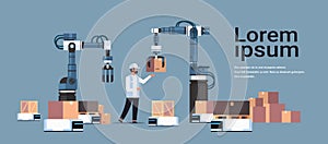 Man engineer controlling robotic hands putting boxes on robot car product deliver factory automation production concept