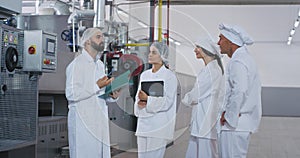 Man engineer and his assistance have a meeting at food industry factory he explains the instructions and security notes