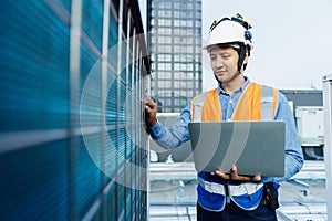 Man engineer holding laptop working at rooftop building construction. Male technician worker working checking hvac of office