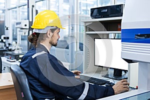 Man engineer using computer blank white screen controlling cnc machine at workshop. Male control automated machine process