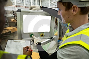 Man engineer using computer blank white screen controlling machine at workshop. Male control automated machine process programming