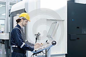 Man engineer using computer controlling cnc machine at workshop. professional male control automated machine process programming