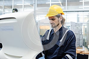 Man engineer using computer controlling cnc machine at workshop. professional male control automated machine process programming