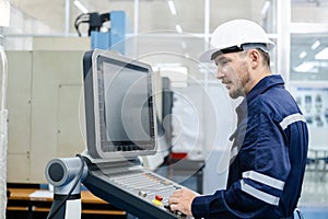 Man engineer using computer controlling cnc machine at workshop. professional male control automated machine process programming