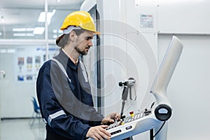 Man engineer using computer controlling cnc machine at workshop. professional male control automated machine process programming