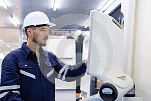 Man engineer using computer controlling cnc machine at workshop. professional male control automated machine process programming