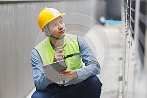 Man engineer using tablet working at rooftop building construction. Male technician worker working checking HVAC of office