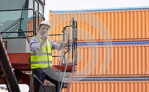 Man engineer using walkie-talkie in shipping yard, Industrial worker is controlling container loading by walkie talkie in import-