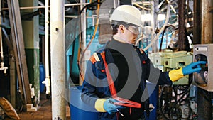 A man engineer walking in manufacturing plant and pushing buttons