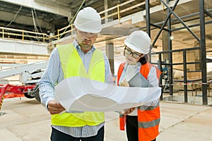 Man engineer and woman architect at a construction site. Building, development, teamwork and people concept